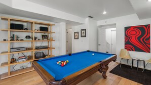 A room with a pool table, a wooden shelf unit, and a painting on the wall. - Modern Mountain Retreat - 4-bedroom, family friendly, peaceful (Durango)