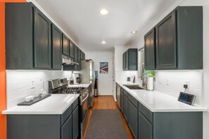 A modern kitchen with dark cabinets, white countertops, and stainless steel appliances. - Modern Mountain Retreat - 4-bedroom, family friendly, peaceful (Durango)