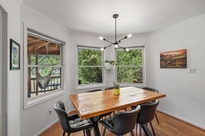 A dining area with a wooden table, black chairs, and a hanging plant. - Modern Mountain Retreat - 4-bedroom, family friendly, peaceful (Durango)