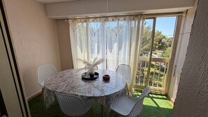 Ein runder Tisch mit vier Stühlen, einer dekorativen Tischmitte und Blick auf einen Garten durch eine Glastür.