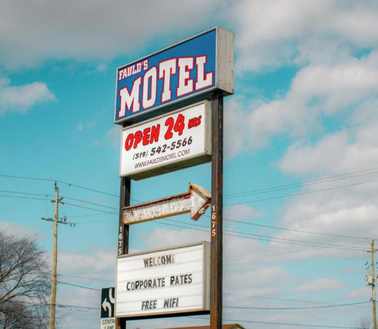 A motel signboard with 'FAULD'S MOTEL' and 'OPEN 24 hrs' prominently displayed.