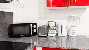 A kitchen with a microwave, toaster, coffee maker, and blender on a granite countertop. - Jasmin: Spacious, quiet apartment with a pool for 6 (Le Gosier)