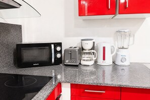 A kitchen with a microwave, toaster, coffee maker, and blender on a granite countertop. - Jasmin: Spacious, quiet apartment with a pool for 6 (Le Gosier)