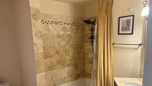 Ein Badezimmer mit Badewanne, Dusche, Toilette und Waschtisch.