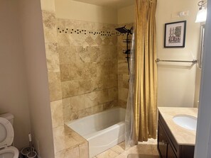 A bathroom with a bathtub, shower, toilet, and vanity. - 2-bedroom apartment in awesome Chicago with cool AC (Chicago)