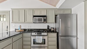 A kitchen with a stove, oven, microwave, and refrigerator.