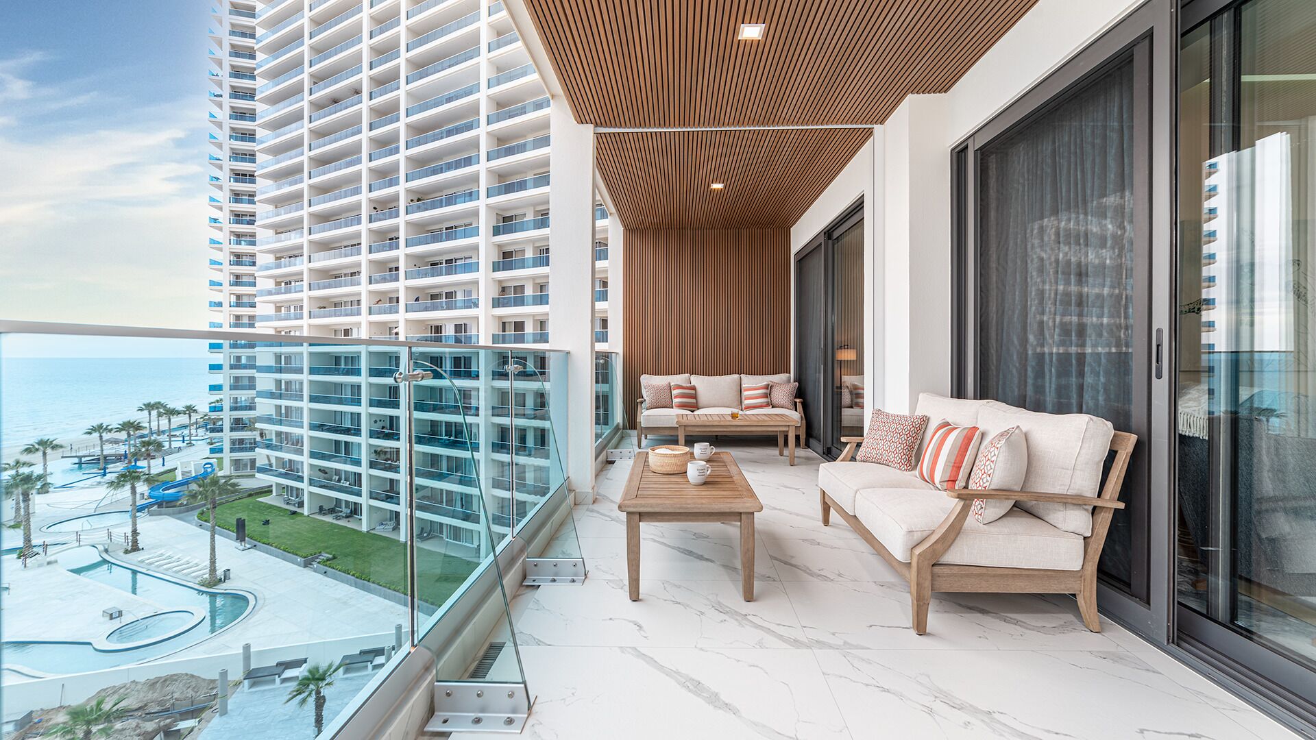 Ein Hochhaus mit Balkon, ausgestattet mit einer Couch, einem Couchtisch und Dekoration.
