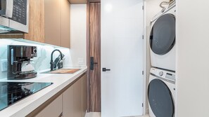 A compact laundry room with a washing machine and dryer, a coffee maker, and a microwave. - R603 Full Unit Luxury Oceanfront Retreat with Stunning High Floor Beachfront Views (Puerto Peñasco)