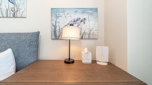 A hotel room with a wooden nightstand, a lamp, a tissue box, and a refrigerator. - R603 Full Unit Luxury Oceanfront Retreat with Stunning High Floor Beachfront Views (Puerto Peñasco)