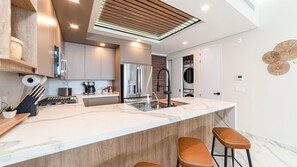 A modern kitchen with a central island, stainless steel appliances, and a skylight. - One-bedroom condo at Encantame Soleil with king bed, ideal for a coastal escape. (Puerto Peñasco)