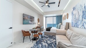 A modern hotel room with a bed, seating area, and a desk. - Encantame Soleil studio with king bed, 1 bath, for up to 2 adults. (Puerto Peñasco)