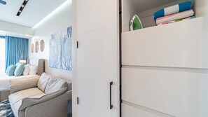 A modern bedroom with a bed, a sofa, a wardrobe, and artwork on the wall. - Encantame Soleil studio with king bed, 1 bath, for up to 2 adults. (Puerto Peñasco)