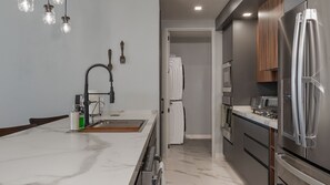 A modern kitchen with a marble countertop, stainless steel appliances, and a built-in oven. - R804 Encantame Soleil 3BR Ocean View Condo with Modern Kitchen and Private Balcony (Puerto Peñasco)
