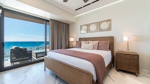 A bedroom with a bed, bedside tables, a nightstand, a view of the ocean, and a balcony with outdoor furniture. - R504 Beachfront 3BR Condo with Ocean Views and Private Balcony at Encantame Soleil (Puerto Peñasco)