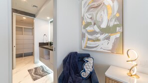 A modern bathroom with a marble floor, a towel rack, a sink, and a wall-mounted light fixture. - Stunning 2 bedroom High Floor Retreat at Encantame Soleil! (Puerto Peñasco)