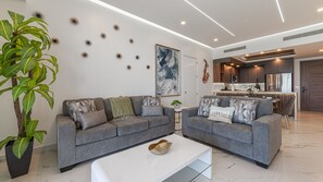 Ein modernes Wohnzimmer mit grauem Sofa, Couchtisch und Wanddekoration.