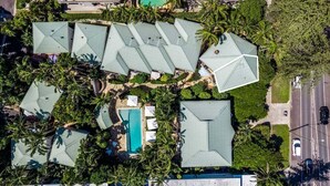 An aerial view of a resort with multiple buildings, a swimming pool, and lush greenery. - Sea Crest- Unit 5, 47 Shirley St, The Crest Apartments (Byron)