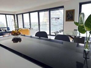 A modern kitchen with a large island, a bowl of fruit, and a potted plant. - Vista al Caribe · 4 balcones · Plaza Marina · TOP (Cancún)