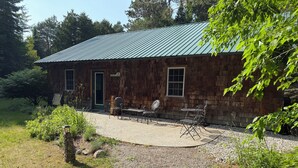 A cabin with a gravel patio and outdoor seating. - Spacious, waterfront privacy in Lake Leelanau , the heart of Leelanau County (Lake Leelanau)