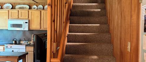 A staircase with a wooden railing leading to a second floor.