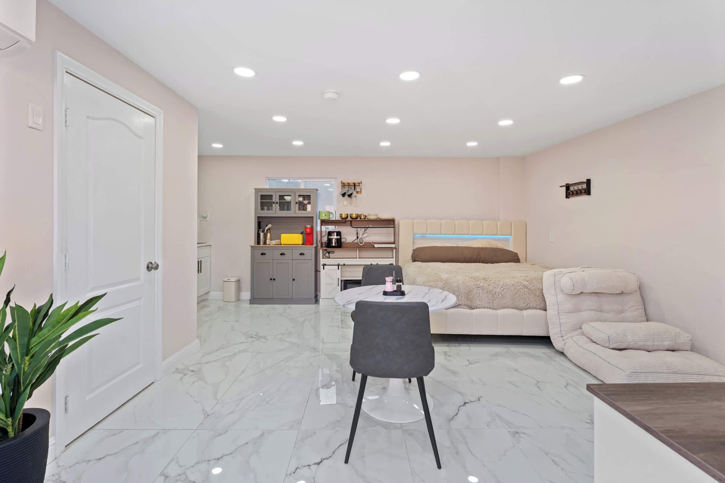 A compact living space with a dining area, kitchenette, and a bed.