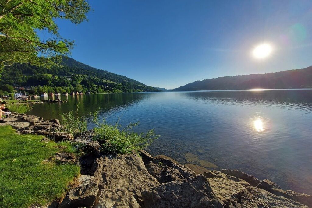 Un lago tranquilo de aguas cristalinas, rodeado de costas rocosas y vegetación.