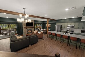 Una cocina moderna con una isla central, taburetes de bar y una chimenea.