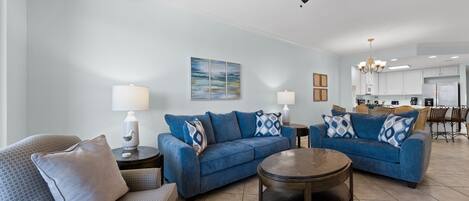 A modern living room with a sofa set, a coffee table, and a ceiling fan.
