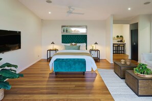 A modern bedroom with a large bed, a ceiling fan, a TV, and a dining area with chairs and a table. - The Jasmine Studio - Montville Romantic Escape (Hinterland Region)