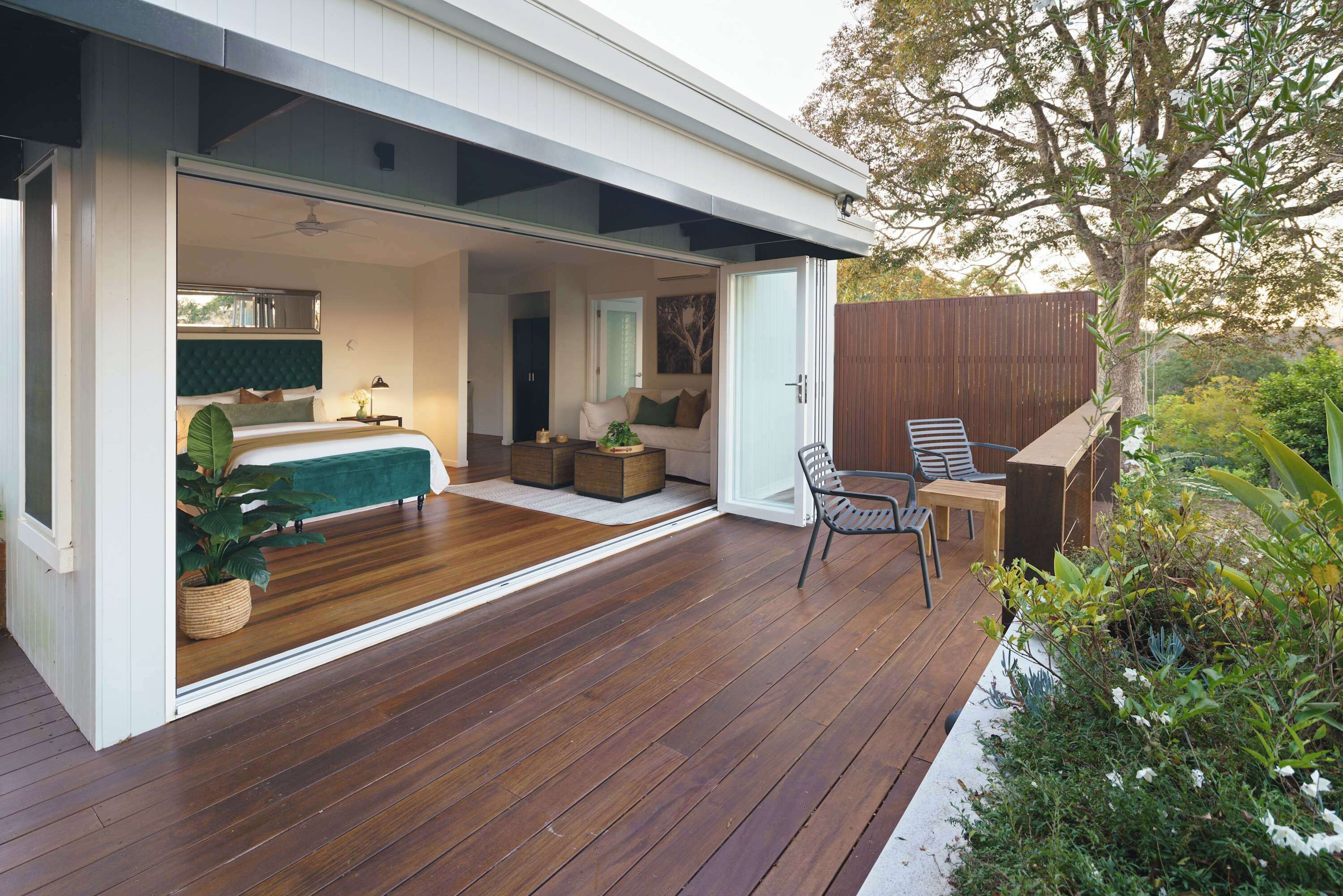 Una casa moderna con un espacio de estar integrado, una terraza de madera y un jardín.