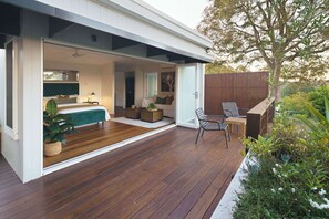 A modern house with an open-plan living area, a wooden deck, and a garden. - The Jasmine Studio - Montville Romantic Escape (Hinterland Region)