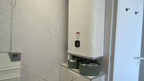 A bathroom with a toilet, a water heater, and a door. - PORNICHET - FACE MER (PORNICHET)