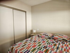 A bedroom with a bed, pillows, a nightstand, and a lamp. - PORNICHET - FACE MER (PORNICHET)