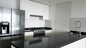 A modern kitchen with stainless steel appliances, a built-in water dispenser, and a sleek black countertop. - TOP/2BR/Home Away From Home/Ocean views/Balcony/HZ (Cancún)