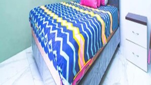 A bed with a patterned bedspread, a pillow, and a bedside table with drawers. - Cozzy Villa Gardenia (batu)