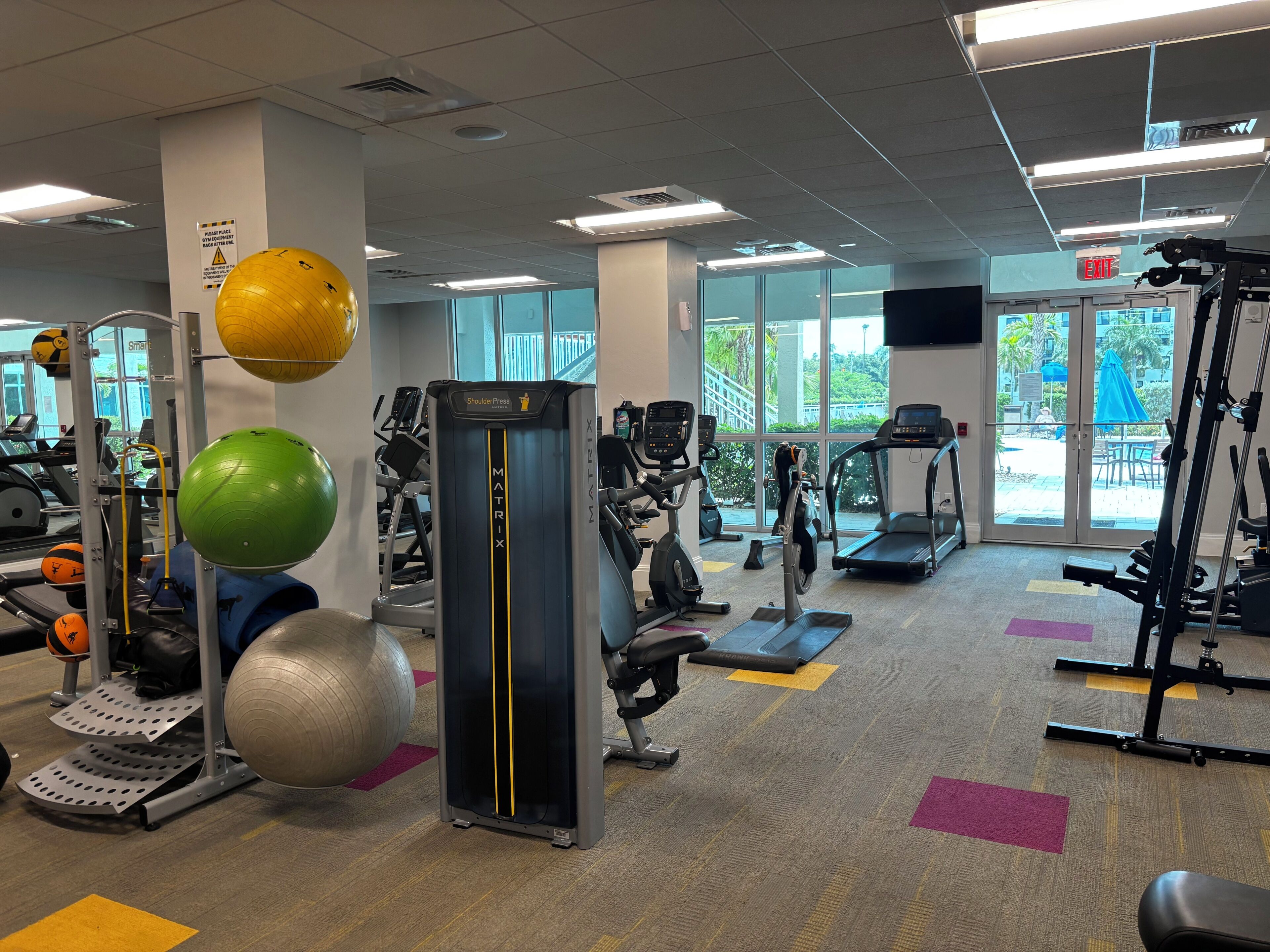 A gym with treadmills, elliptical machines, and various exercise equipment.