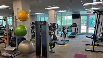A gym with treadmills, elliptical machines, and various exercise equipment.