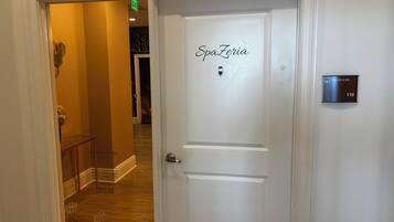 A hotel room entrance with a door labeled 'SpaZeria' and a room number sign.