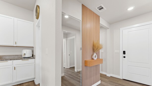 A modern kitchen with white cabinetry, a built-in oven, and a countertop with a coffee maker. - Unforgettable 4BD Oasis in West Texas (Midland)