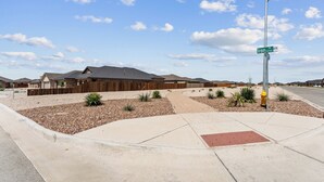 A residential area with houses, a street sign, and a clear sky. - Unforgettable 4BD Oasis in West Texas (Midland)