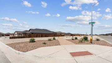 Un quartier résidentiel avec des maisons, un panneau de signalisation et un ciel dégagé.
