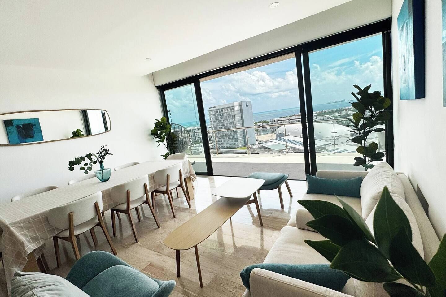 Un salon moderne avec un coin repas, de grandes fenêtres et une vue sur le paysage urbain.
