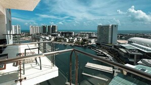 Un edificio alto con vistas a un puerto deportivo y otros edificios.