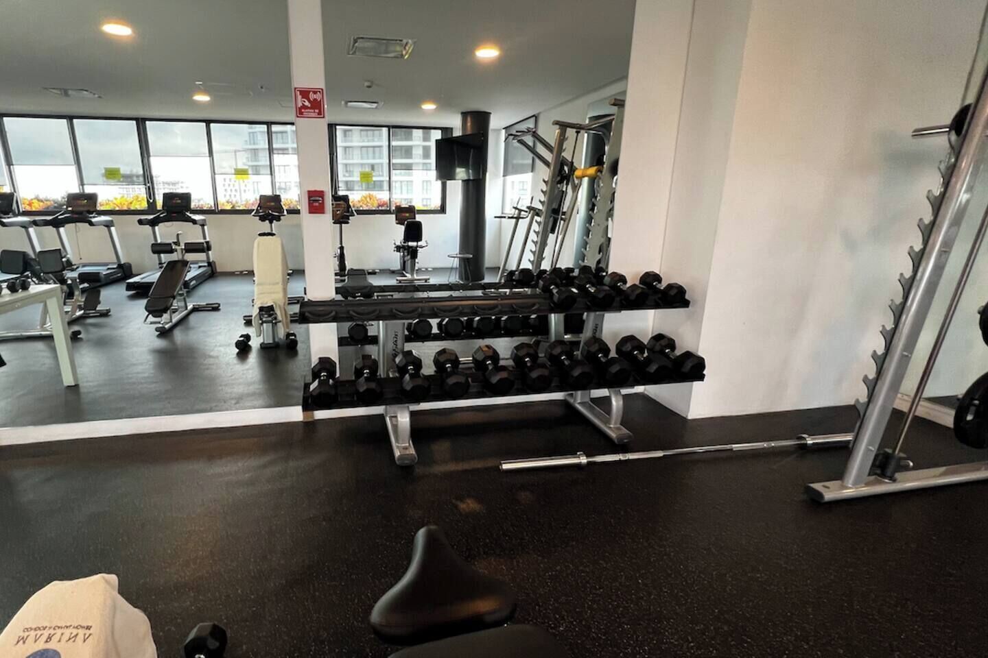 Ein Fitnessstudio mit Laufbändern, Hanteln und Krafttrainingsgeräten.