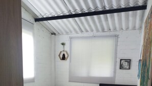 A room with two beds, a window with blinds, a wall-mounted decoration, and a tiled floor. - Country house with a deck, BBQ, and small pool (Risaralda)