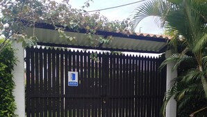 A gated entrance with a gravel path leading to a building with a tiled roof. - Country house with a deck, BBQ, and small pool (Risaralda)
