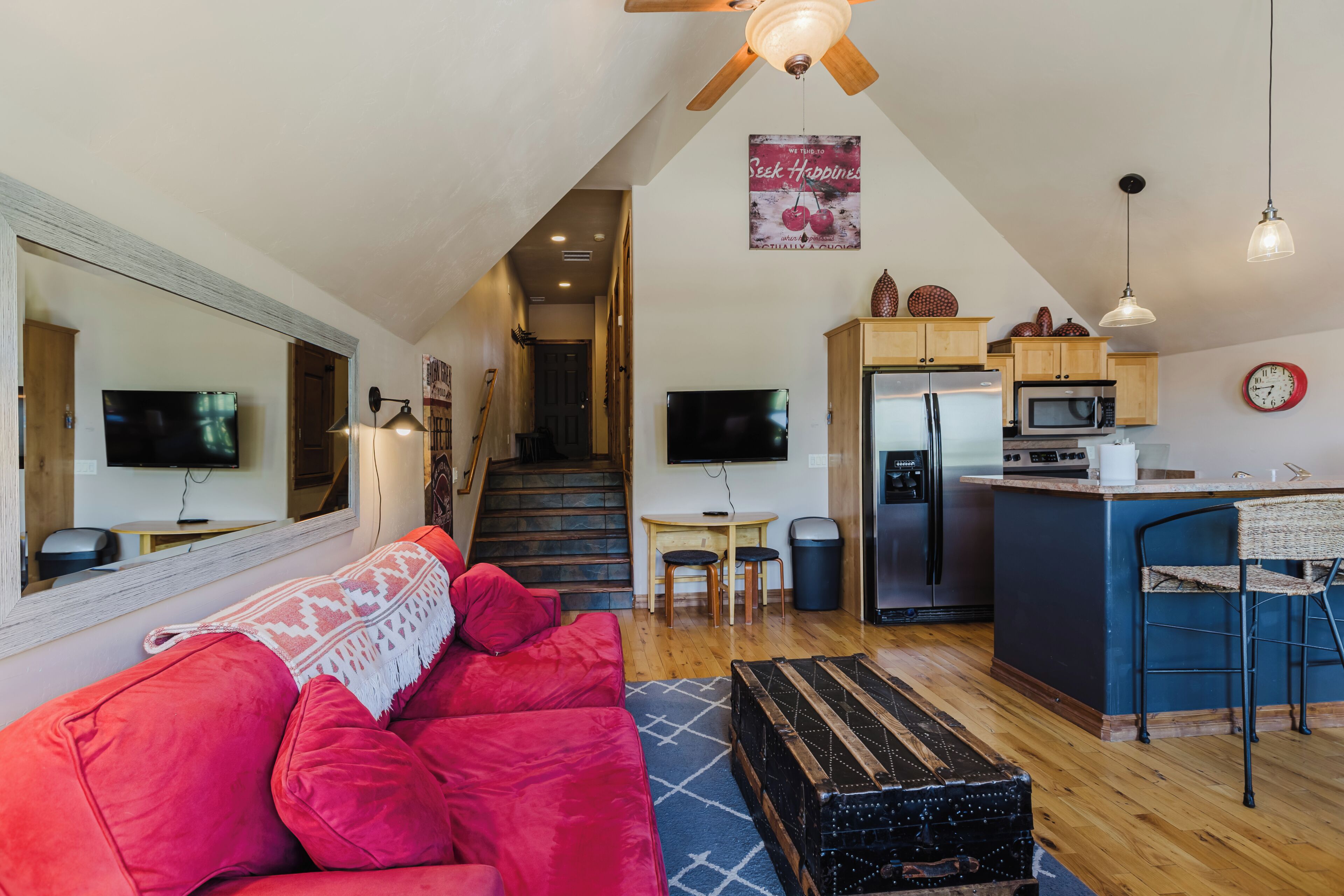 A compact living space with a kitchenette, a sofa, a dining table, and a television.
