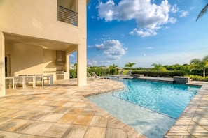 A swimming pool with a tiled deck, lounge chairs, and a covered patio area. - The Eighteen at Bear's Den, Water Park, Golf Views, Near Disney (Kissimmee)