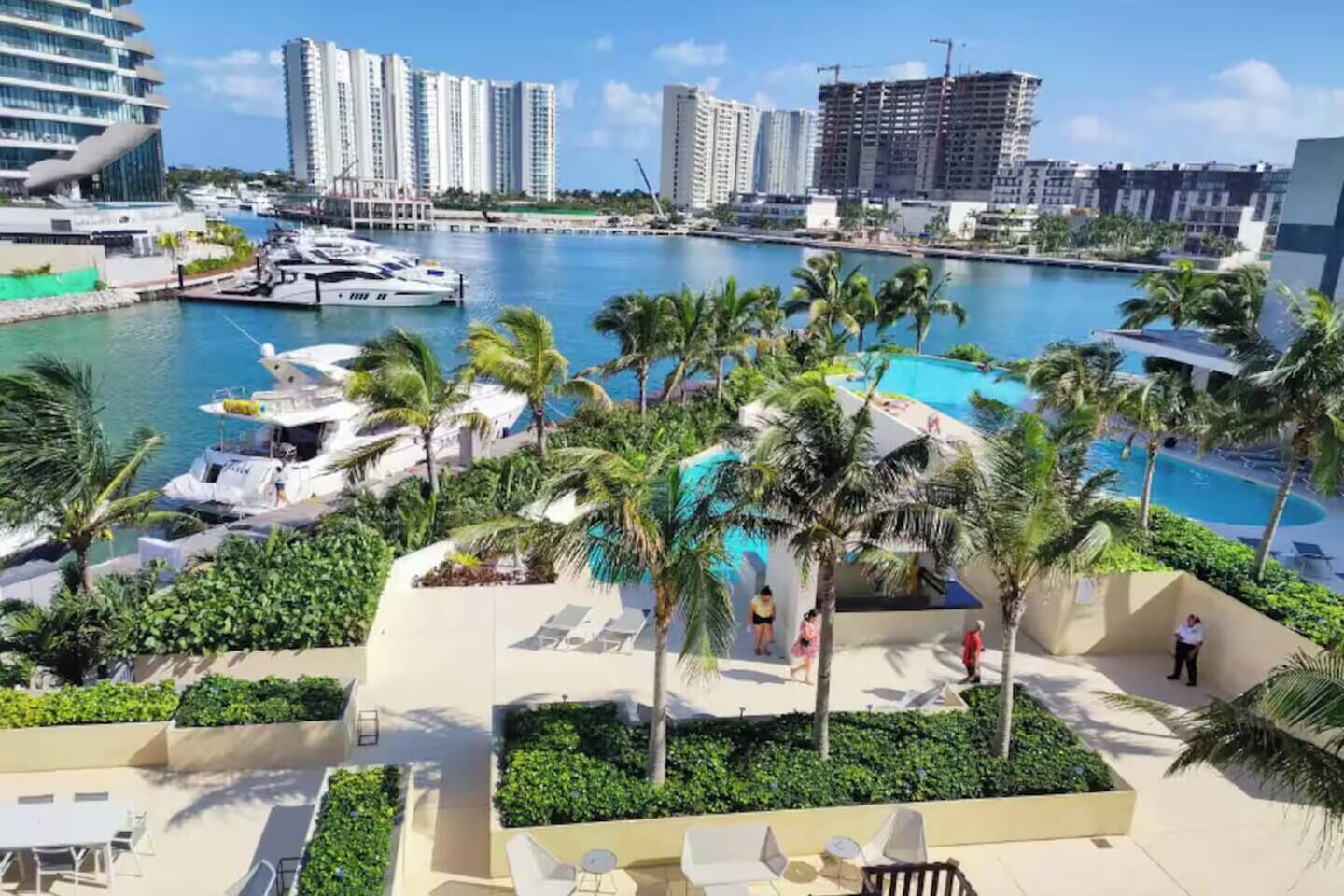 Ein Resort mit Pool, Palmen und einer Marina mit Booten.