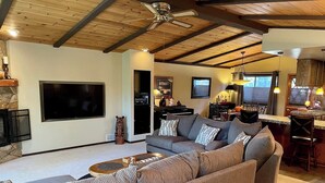 A living room with a sectional sofa, a flat-screen TV, and a ceiling fan. - Ultimate Mountain Retreat! (South Lake Tahoe)